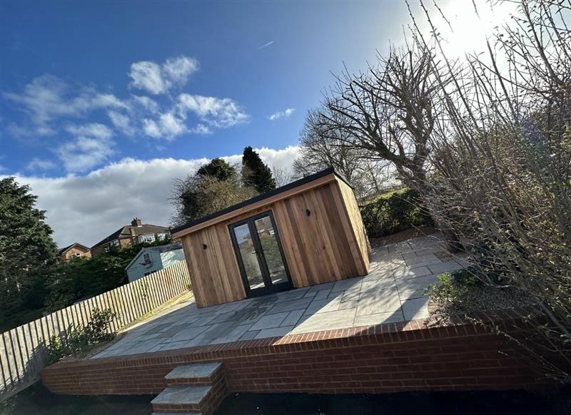 Timber garden room set on a new sandstone patio with brick retaining wall