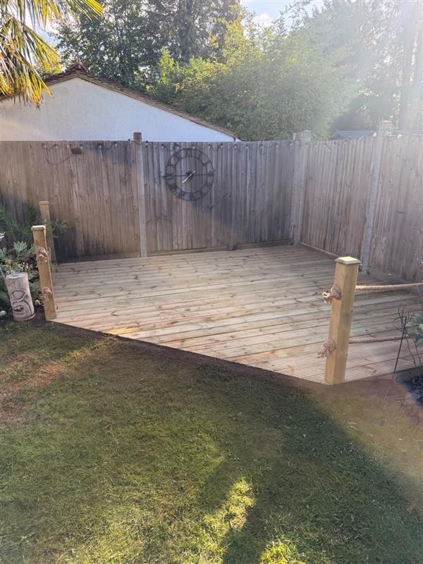 Softwood timber deck with rope balustrade posts in a rear garden