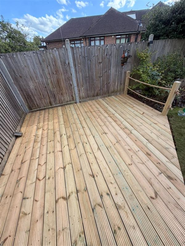 New softwood decking area with rope handrail beside a lawn