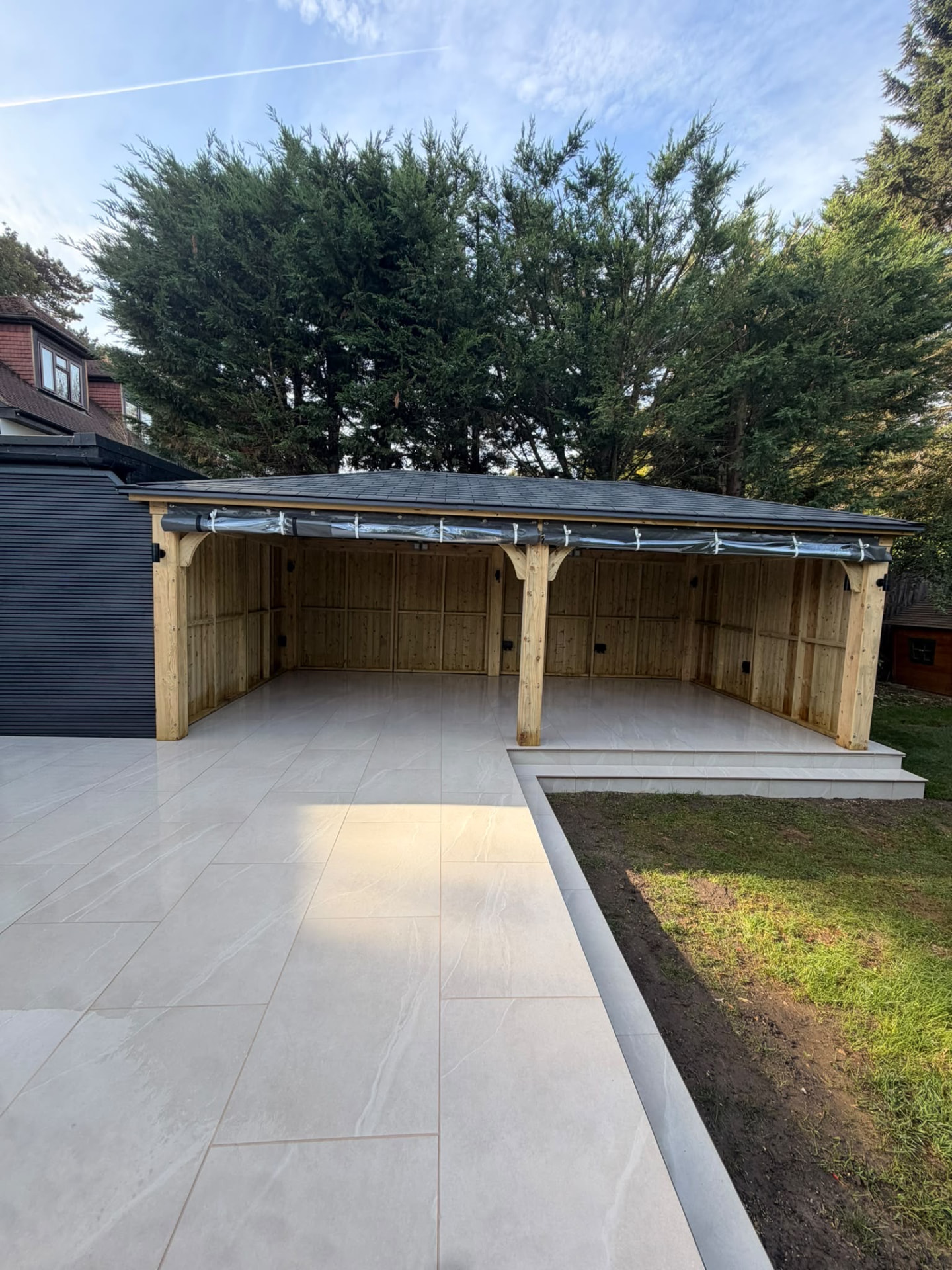 Porcelain patio leading to a covered timber garden room at Portnalls Road, Coulsdon