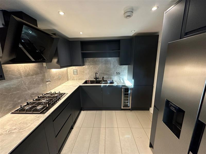 Matt graphite fitted kitchen with marble effect worktops and integrated appliances