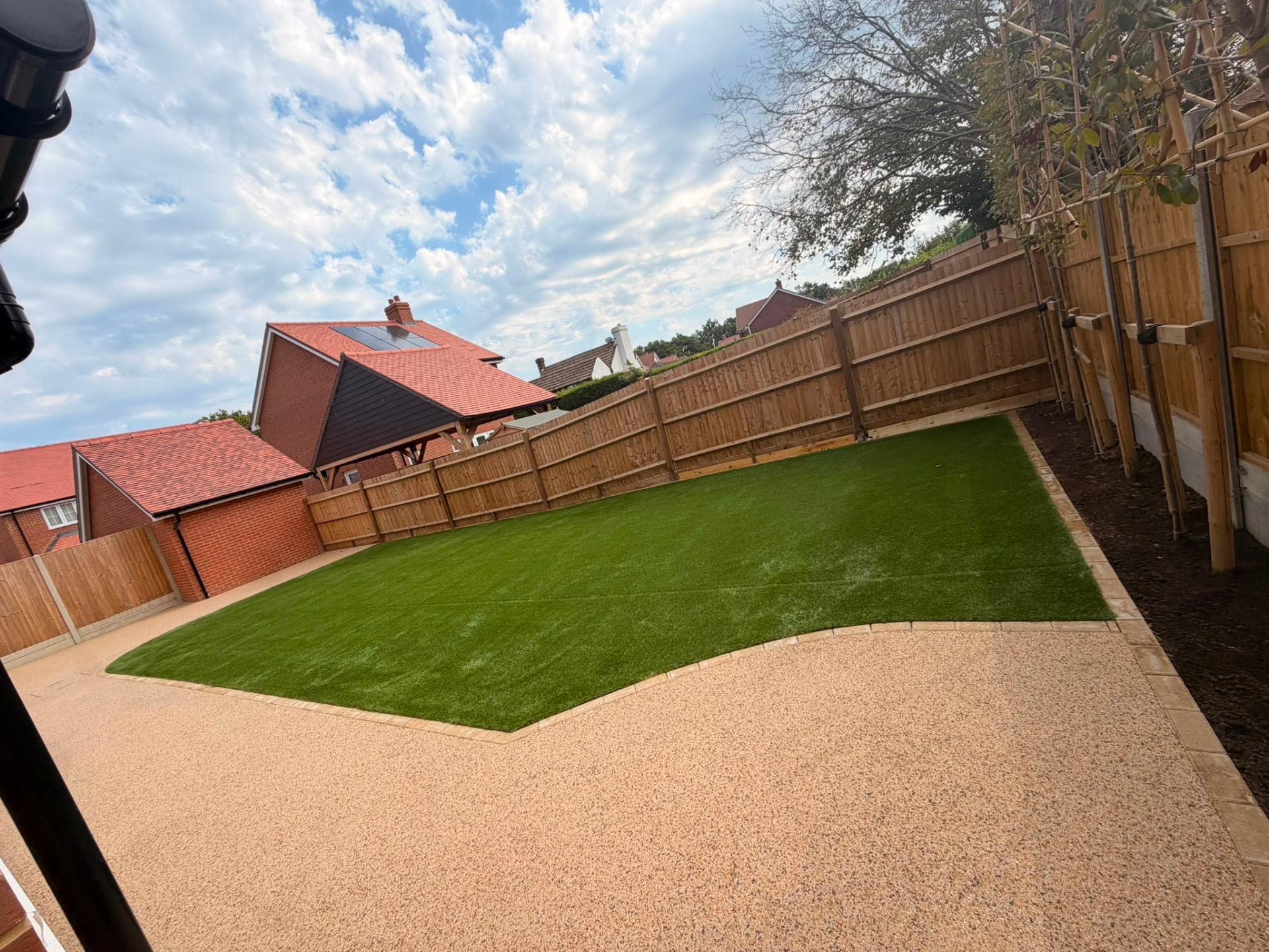 Complete rear garden makeover with shaped artificial lawn, resin surfacing and new fencing