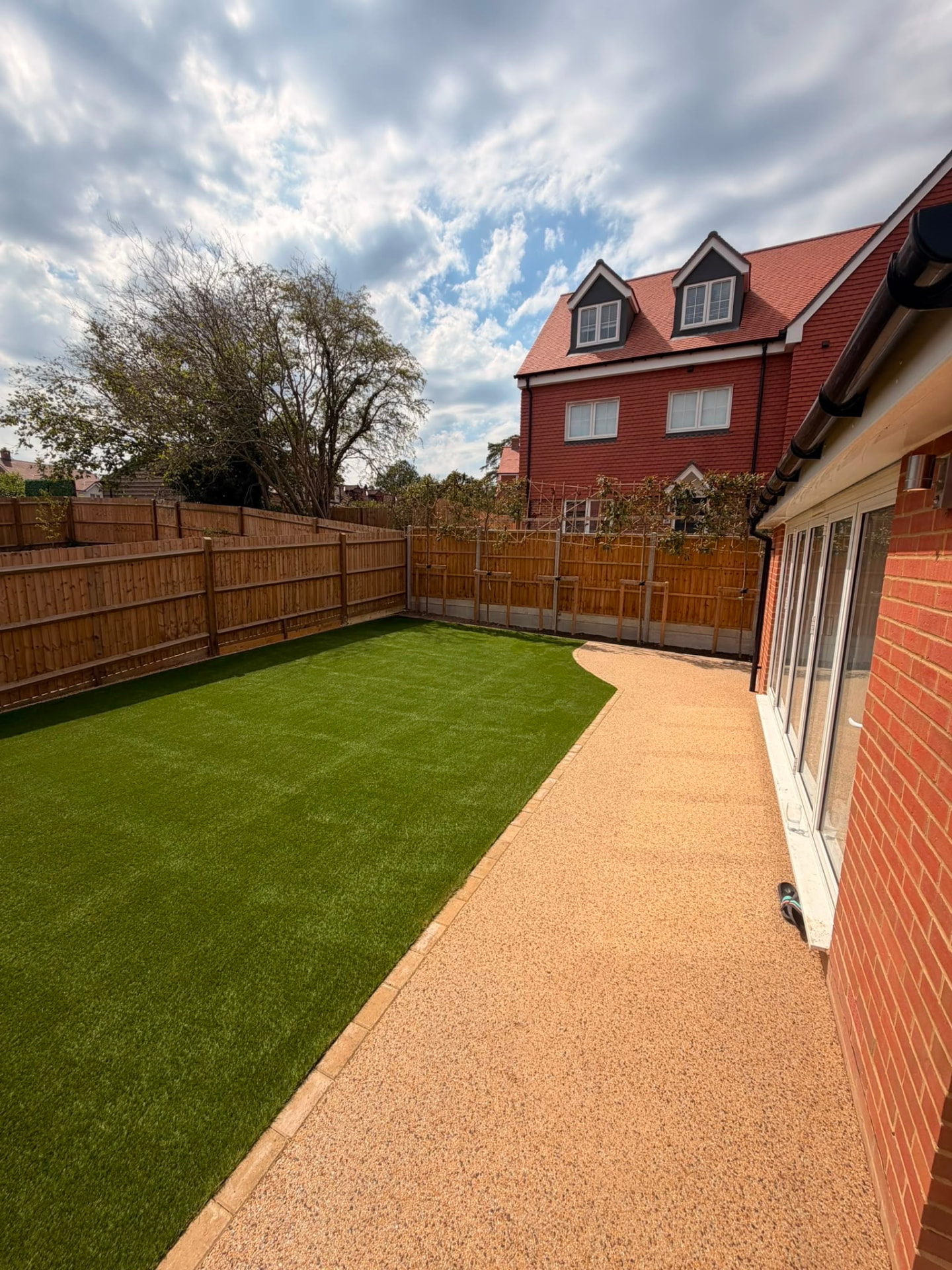 Rear garden with artificial lawn, resin bound path and closeboard fencing